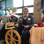 Sharon Koecher sits at her spinning wheel and shows off her wares during the Fireweed FiberFest at the Soldotna Regional Sports Complex in Soldotna, Alaska on Sept. 28, 2019. (Photo by Brian Mazurek/Peninsula Clarion)