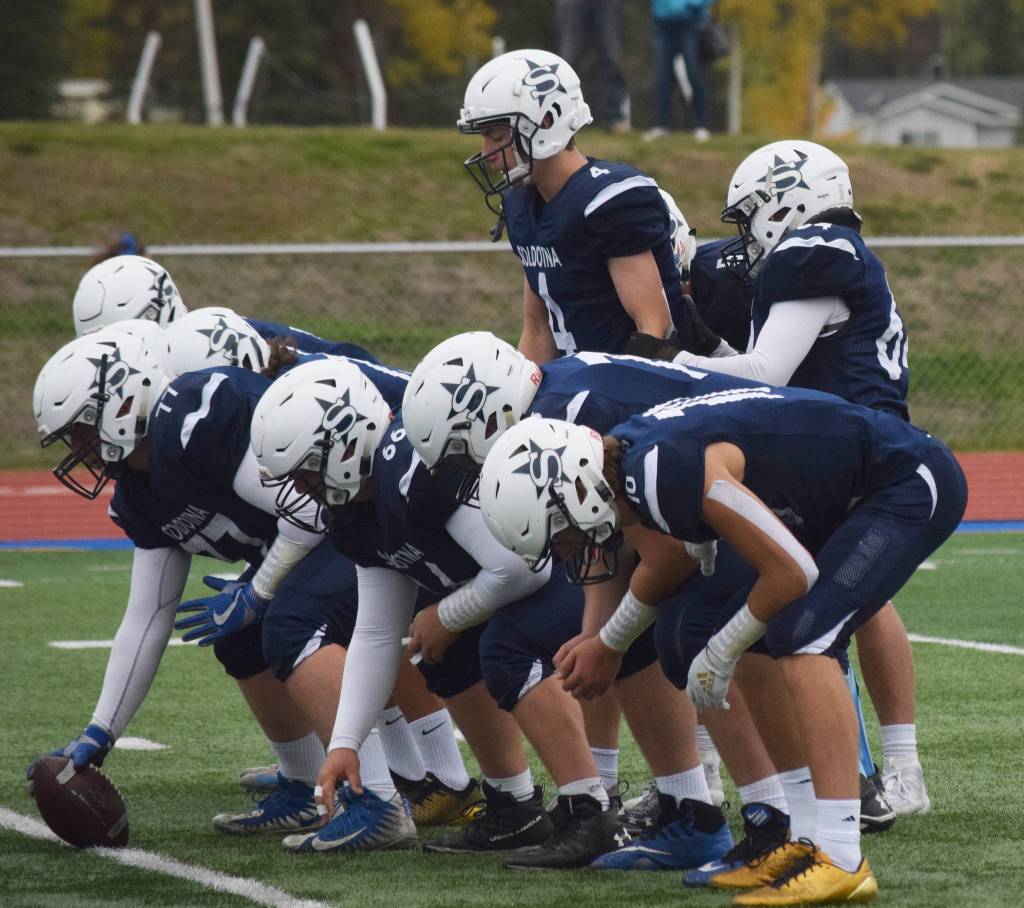 Soldotna senior Matthew Martinelli (upper right) takes the first snap of the game Saturday against Eagle River at Justin Maile Field in Soldotna. (Photo by Joey Klecka/Peninsula Clarion)