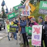 Supporters wave signs in support of Proposition A, to ban single-use plastic bags, and for Homer City Council candidates Joey Evensen and Storm Hansen-Cavasos on Tuesday, Oct. 1, 2019, at WKFL Park in Homer, Alaska. (Photo by Michael Armstrong/Homer News)