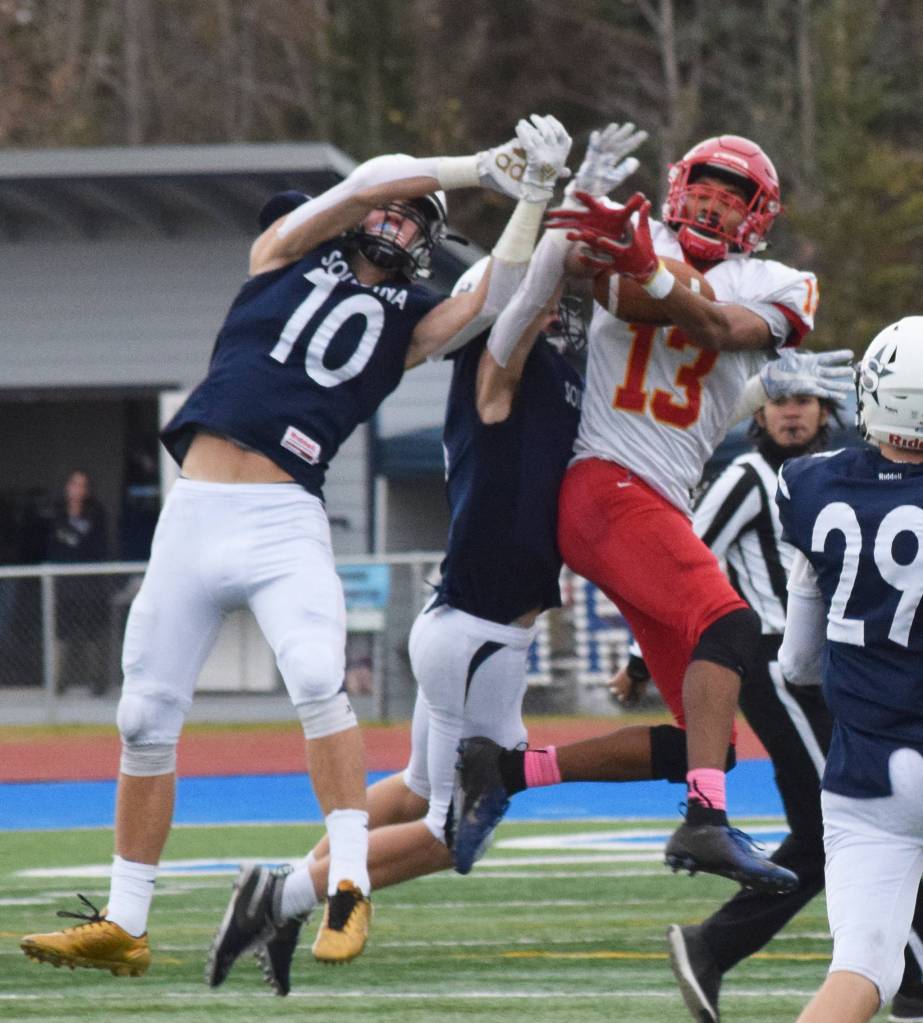 West Valleys Tyriq Nance (13) hauls in a reception with Soldotna defenders Zach Hanson (10) and Jersey Truesdell defending in a Div. II state semifinal Friday, Oct. 11, 2019, in Soldotna, Alaska. (Photo by Joey Klecka/Peninsula Clarion)