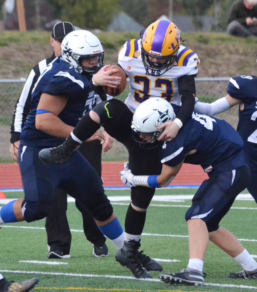 Lathrop running back Josiah Opp gets swarmed by Soldotnas Melvin Lloyd (left) and Jersey Truesdell Friday, Sept. 13, 2019, at Justin Maile Field in Soldotna, Alaska. (Photo by Joey Klecka/Peninsula Clarion)