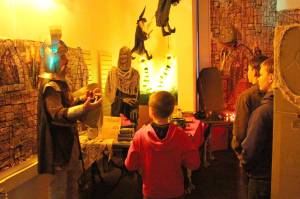 Sir James Adcox, left, leads Silas Barnes, Manoah Barnes and Nehemiah Barnes through the Literary Haunted House at the Kenai Community Library on Oct. 30, 2019. (Photo by Brian Mazurek/Peninsula Clarion)