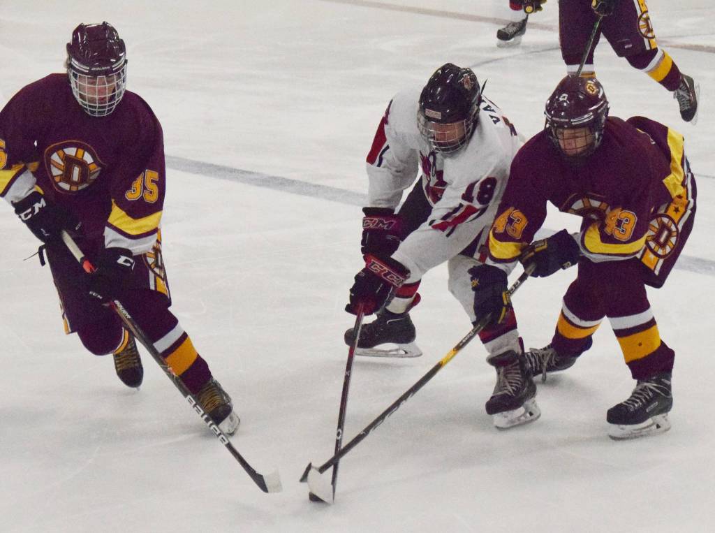 Kenais Tucker Vann battles for the puck with Dimonds Dakota Toombs (left) and Colton Reid, Friday, Nov. 1, 2019, at the Peninsula Ice Challenge tournament at the Kenai Multi-Purpose Facility in Kenai, Alaska. (Photo by Joey Klecka/Peninsula Clarion)