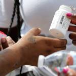 In this July photo Ivette Naida, left, receives HIV medication from social workers from the IDEA Exchange. HIV medication is part of the reason transmission rates of the virus are low in Alaska. (AP Photo | Lynne Sladky)