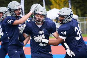 Soldotna running back Brenner Furlong (center) receives congratulations from teammates Zach Hanson (left) and Aaron Faletoi (right) after scoring a touchdown in Sept. 2017 at Justin Maile Field in Soldotna. (Photo by Joey Klecka/Peninsula Clarion)