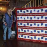 John Benya stands by a Quilt of Valor presented to him at the Veterans Day lunch held at the Elks Lodge on Nov. 11, 2019, in Homer, Alaska. To his right is his daughter, Joy Davis. Benya served in the U.S. Army from 1965-66, including a tour in Vietnam, where he was wounded in action. (Photo by Michael Armstrong/Homer News)