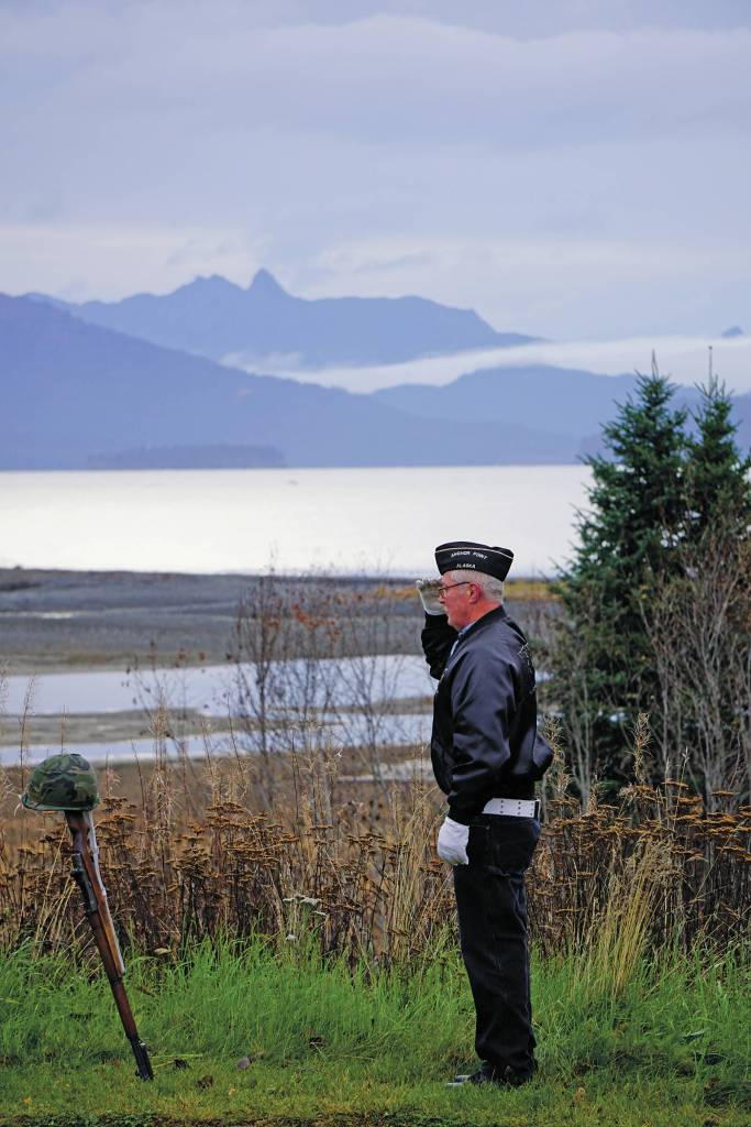 Eric Henley of the Veterans of Foreign Wars, Anchor Point Post, salutes a helmet and rifle  symbolizing those lost in U.S. wars  on Nov. 11, 2019, for Veterans Day ceremonies at the Alaska Islands and Ocean Visitor Center in Homer, Alaska. (Photo by Michael Armstrong / Homer News)