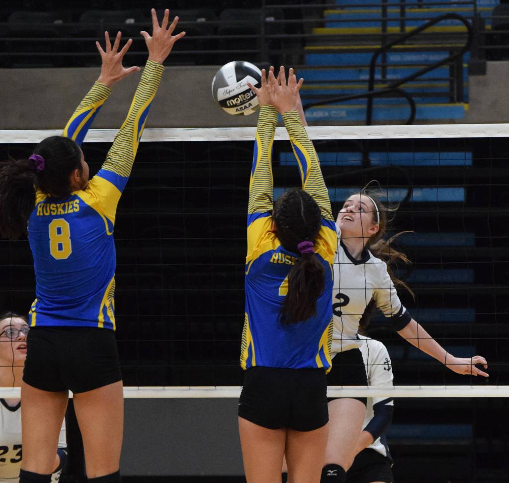 Homers Laura Inama tips a ball over Kotzebues Laveah Makisi (left) and Kaila Short, Thursday, Nov. 14, 2019, at the Class 4A state volleyball tournament at the Alaska Airlines Center in Anchorage, Alaska. (Photo by Joey Klecka/Peninsula Clarion)