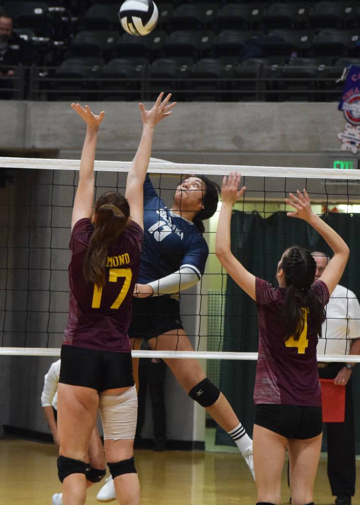 Soldotnas Ituau Tuisaula sends a ball over Dimonds Kimberly Roth (left) and Kadyn Osborne, Thursday, Nov. 14, 2019, at the Class 4A state volleyball tournament at the Alaska Airlines Center in Anchorage, Alaska. (Photo by Joey Klecka/Peninsula Clarion)