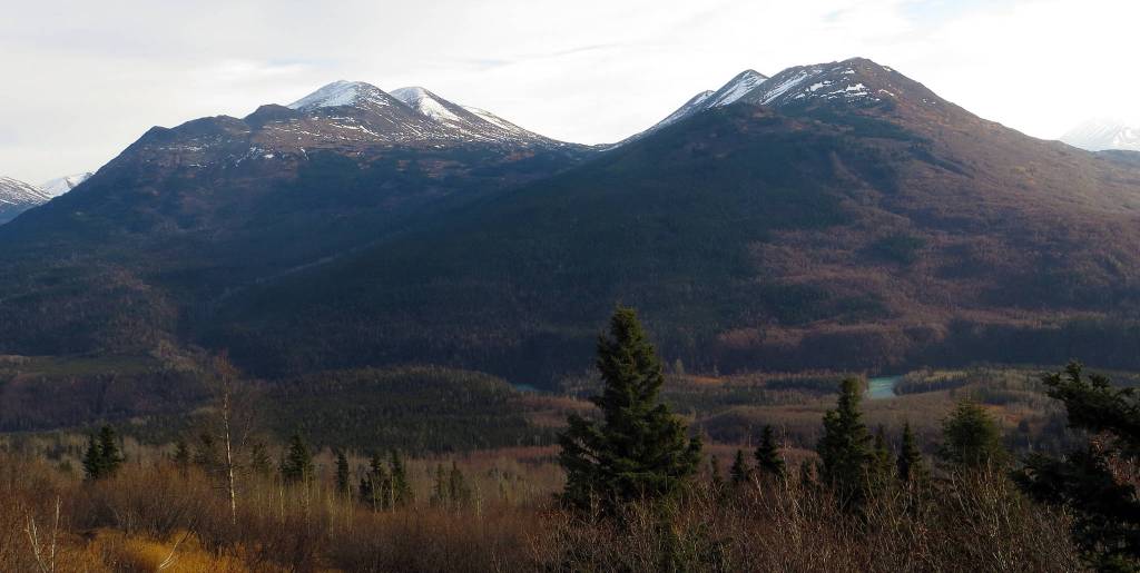 The crescent-shaped Surprise Creek drainage begins between the snow-tinged Russian (left) and Bear mountains and empties into the Kenai River canyon near the bottom center of this image. (Photo by Clark Fair)