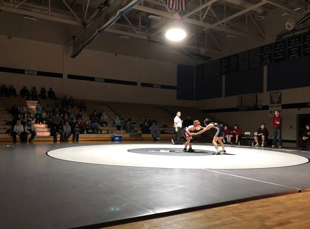 A lone spotlight highlights the action Tuesday, Nov. 19, 2019, at a Kenai/Nikiski dual meet at Nikiski High School. (Photo by Joey Klecka/Peninsula Clarion)