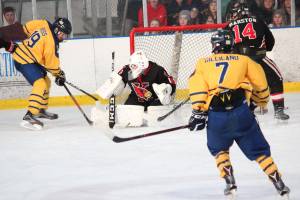 Homers Alden Ross (left) tries to get the puck past Kenai goalie Thomas Baker during a Saturday, Nov. 23, 2019 hockey game at Kevin Bell Arena in Homer, Alaska. (Photo by Megan Pacer/Homer News)