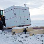This undated photo in Kaktovik, Alaska, shows installation of a shelter covering the entrance to a new community ice cellar, a type of underground food cache dug into the permafrost to provide natural refrigeration used for generations in far-north communities. Naturally cooled underground ice cellars, used in Alaska Native communities for generations, are becoming increasingly unreliable as a warming climate and other factors touch multiple facets of life in the far north. (Marnie Isaacs/Kaktovik Community Foundation via AP)