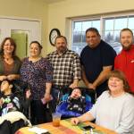 From left, Connie Combs, Brent Takak, Andrea Combs, Don Combs, Finley Combs, Clint Hagel, Jennifer Hagel and Billy Yoder smile for the camera during the Thanksgiving community potluck at College Heights Baptist Church in Soldotna, Alaska, on Thursday, Nov. 28, 2019. (Photo by Brian Mazurek/Peninsula Clarion)