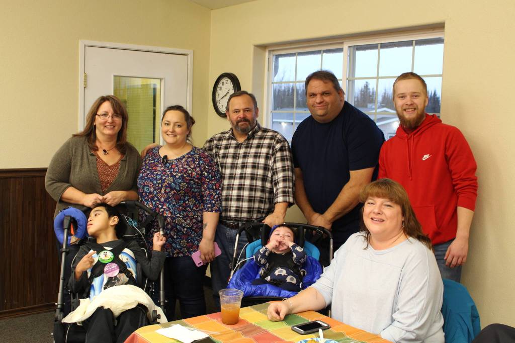 From left, Connie Combs, Brent Takak, Andrea Combs, Don Combs, Finley Combs, Clint Hagel, Jennifer Hagel and Billy Yoder smile for the camera during the Thanksgiving community potluck at College Heights Baptist Church in Soldotna, Alaska, on Thursday, Nov. 28, 2019. (Photo by Brian Mazurek/Peninsula Clarion)