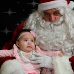 This Dec. 3, 2019, photo shows 6-month-old Rebecca Ilmar having her photo taken with Santa Claus in Napakiak, Alaska. The Alaska National Guard brought its Operation Santa Claus to the western Alaska community, which is being severely eroded by the nearby Kuskokwim River. (AP Photo/Mark Thiessen)