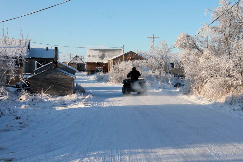 This Dec. 3, 2019, photo shows a man driving a four-wheeler down a street in Napakiak, Alaska. The Alaska National Guard brought its Operation Santa Claus to the western Alaska community, which is being severely eroded by the nearby Kuskokwim River. (AP Photo/Mark Thiessen)
