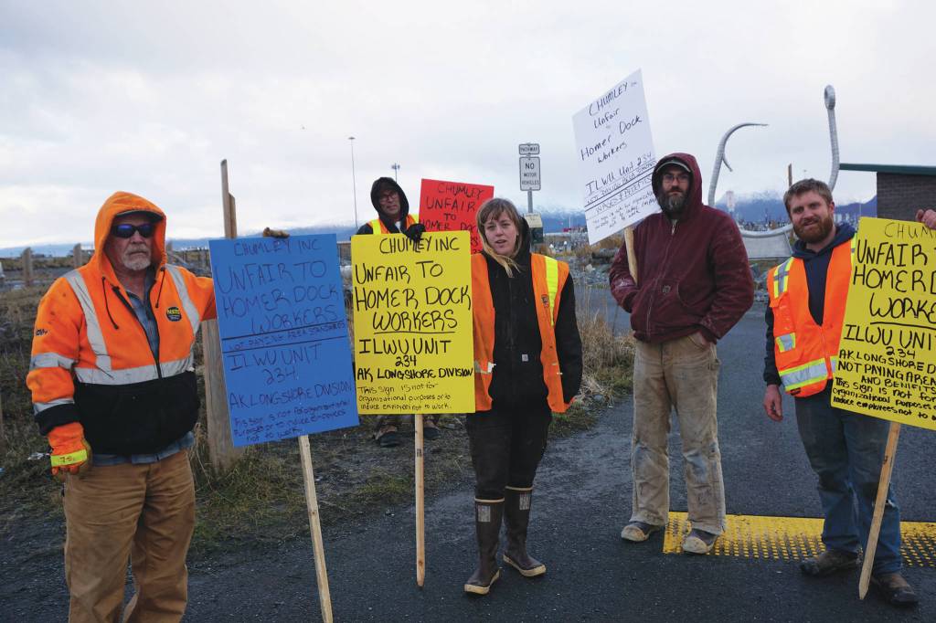 Homer longshore workers picket on the Homer Spit by Freight Dock Road on Tuesday, Dec. 17, 2019, in Homer, Alaska. They were part of a group of about 20 Alaska International Longshore and Warehouse Union members or supporters hold an area standards picket in response to Chumleys Inc. use of workers to load a sulfur hauler ship the ILWU alleges are paid substandard wages. From left to right, are Grant Lane, Paul Gregoire, Carley Conemac, Jeff Allmendinger and Brian Dingman. (Photo by Michael Armstrong/Homer News)