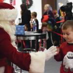 Joey Klecka / Peninsula Clarion                                Santa Claus gives a young fan a high five Nov. 29 at the Christmas Comes to Kenai celebration at the Kenai Visitor and Cultural Center.