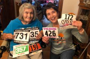 Salli Sterrett receives race bibs from her daughter, Sheilah-Margaret Pothast, in Arizona in late October. Pothast is doing 50 races in her 50th year for her mother. (Photo provided by Sheilah-Margaret Pothast)