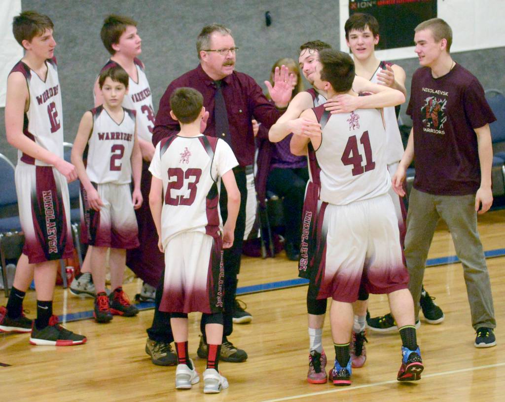 Nikolaevsk coach Steve Klaich celebrates with his team after winning his first Peninsula Conference title in his 30th season at the helm at Cook Inlet Academy in Soldotna. (Photo by Jeff Helminiak/Peninsula Clarion)