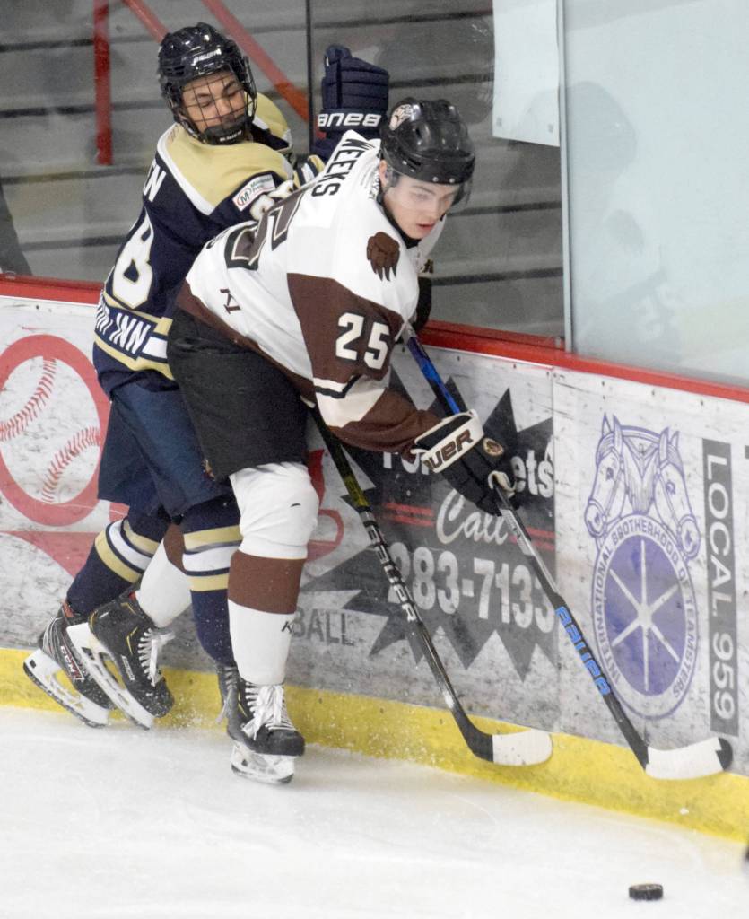 Kenai River Brown Bears defenseman Preston Weeks, of Soldotna, shields the puck from Janesville (Wisconsin) Jets defenseman Charlie Schoen on Friday, Dec. 6, 2019, at the Soldotna Regional Sports Complex in Soldotna, Alaska. (Photo by Jeff Helminiak/Peninsula Clarion)