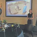 Seward High School students (from left) Tayten Barhaug, Lindy Guernsey and Akilena Veach demonstrate their Caring for the Kenai project, drones to help map the flood planes of Seward, during the Industry Outlook Forum in Seward on Wednesday. (Photo by Kat Sorensen/Peninsula Clarion)
