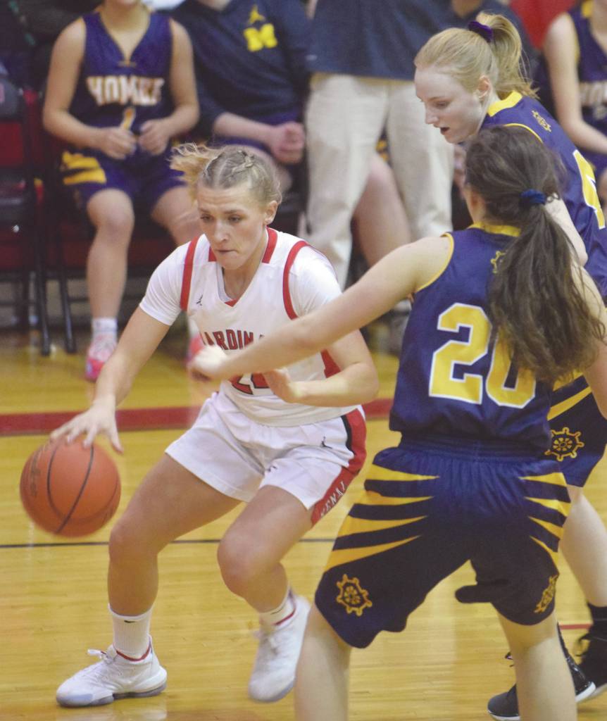 Kenai Centrals Damaris Severson drives on Homers Kelli Bishop and Marina Carroll (20) on Friday, Jan. 10, 2020, at Kenai Central High School in Kenai, Alaska. (Photo by Jeff Helminiak/Peninsula Clarion)