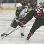 Soldotnas Wyatt Medcoff chips the puck past Houstons Nate Hutchinson on Friday, Jan. 10, 2019, at the Soldotna Regional Sports Complex in Soldotna, Alaska. (Photo by Jeff Helminiak/Peninsula Clarion)
