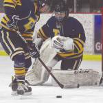 Tri-Valleys Oliver Cole clears the puck out from in front of goalie Danny Renshaw on Friday at the Kenai Multi-Purpose Facility in Kenai. (Photo by Jeff Helminiak/Peninsula Clarion)