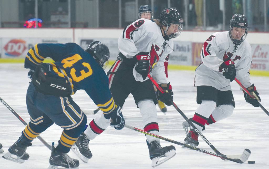 Kenais Hunter Erwin, in front of teammate Jordan Knudsen, keeps the puck from Tri-Valleys Mathius Speer on Friday at the Kenai Multi-Purpose Facility in Kenai. (Photo by Jeff Helminiak/Peninsula Clarion)