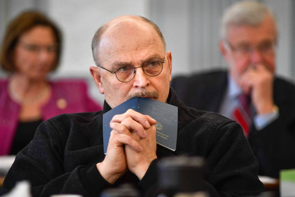 Sen. Click Bishop, R-Fairbanks, rests his head on a Constitution of Alaska booklet as he listens to Donna Arduin, Director of the Office of Management and Budget, and Mike Barnhill, policy director for the OMB, present Gov. Mike Dunleavy’s budget to the Senate Finance Committee at the Capitol on Tuesday, Feb. 18, 2019. Senate President Cathy Giessel, R - Anchorage, left, and Sen. Gary Stevens, R-Kodiak, right, are in the background. (Michael Penn | Juneau Empire)