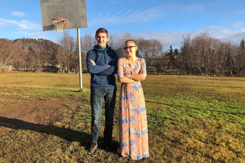 Susanna and Kelsey Reutov, students at Kachemak Selo School, stand outside the middle and high school building on Nov. 12, 2019, in Kachemak Selo, Alaska. (Photo by Victoria Petersen/Peninsula Clarion)