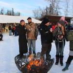 From left, Tiana McGahan, Aaron Hughes, Victor Thompson, McKayla Chadburn and Dawn Rimer keep warm around the fire during the 2020 Frozen RiverFest at Soldotna Creek Park in Soldotna, Alaska on Feb. 15, 2020. (Photo by Brian Mazurek/Peninsula Clarion)