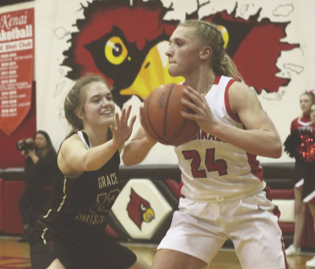 Kenais Damaris Severson passes under pressure from Grace Christians Julia Tanner on Friday, Feb. 21, 2020, at Kenai Central High School in Kenai, Alaska. (Photo by Ben Boettger/For the Clarion)