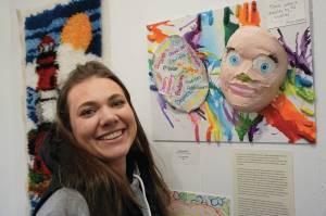 Cora Trowbridge stands by her art, Behind the Mask, on March 6, 2020, at the Disability Art Show at the Homer Council on the Arts in Homer, Alaska. (Photo by Michael Armstrong/Homer News)
