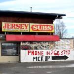 A sign advertising pickup orders can be seen at Kenai sandwich Jersey Subs on Thursday, March 26, 2020. Under new state mandates aiming to prevent the spread of the coronavirus local eateries can only provide takeout services. Under legislation recently passed by the U.S. Senate, small businesses with fewer than 500 employees that have federally guaranteed loans and who keep up their payroll also can get up to eight weeks of payments. (Victoria Petersen/Peninsula Clarion)