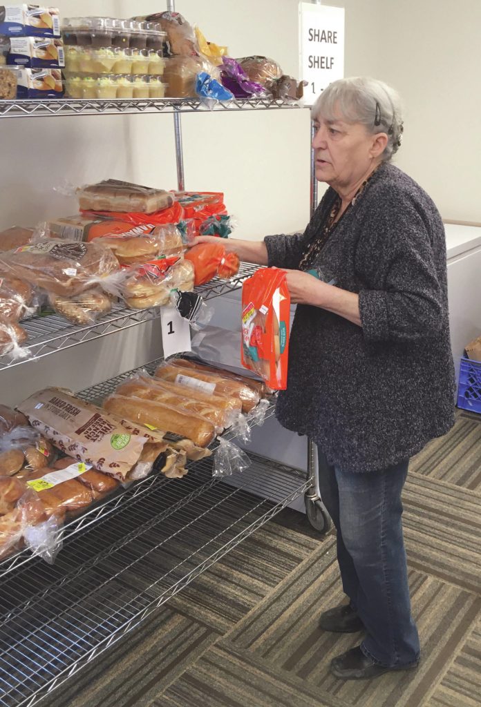Kasilofs Morganette Finch, receptionist at Kenai Peninsula Food Bank in Soldotna, Alaska, gathers items for a food bag pickup on Tuesday, March 31, 2020. (Photo by Jeff Helminiak/Peninsula Clarion)