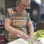 Jeff Helminiak / Peninsula Clarion                                Kasilofs Cheryl Morse, a cook at the Kenai Peninsula Food Bank, chops up scallions for scalloped potatoes Tuesday at the food bank in Soldotna.