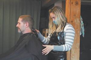 Ashley Story gives a haircut to client Michael Halstead on Friday at her salon Short Cuts on Lake Street in Homer, Alaska. Storys is one of several Homer businesses to reopen their doors Friday according to relaxed state restrictions, while several others have opted to wait. (Photo by Megan Pacer/Homer News)