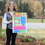 Anna DeVolld poses with an informational poster for her Promote Our Pollinators project in this undated photo. (Photo courtesy Shona DeVolld)
