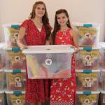 Anna DeVolld and her sister Sara DeVolld pose with some of Annas pollinator packs in this undated photo. (Photo courtesy Shona DeVolld)