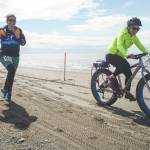 Photo courtesy Kaitlin Vadla                                Heather Renner and Tasha Reynolds run and fat bike to the finish line on the Kenai Beach during the 2019 Mouth to Mouth Wild Run & Ride.