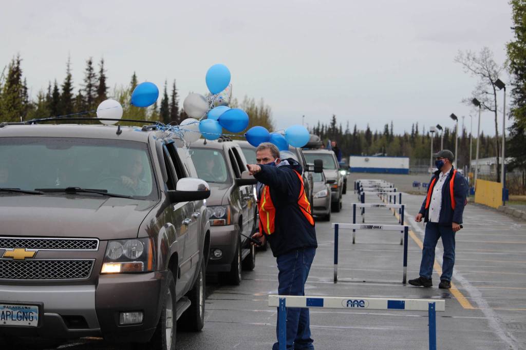 Faculty members of Soldotna High School direct the procession of cars during Soldotna High Schools 2020 graduation in Soldotna, Alaska on May 18, 2020. (Photo by Brian Mazurek/Peninsula Clarion)