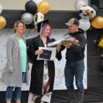 Alexis Kreger takes a bouquet of flowers from her dad, Jesse, during the Connections Homeschool Class of 2020 graduation at Soldotna Elementary School in Soldotna, Alaska on May 21, 2020. (Photo by Brian Mazurek/Peninsula Clarion)