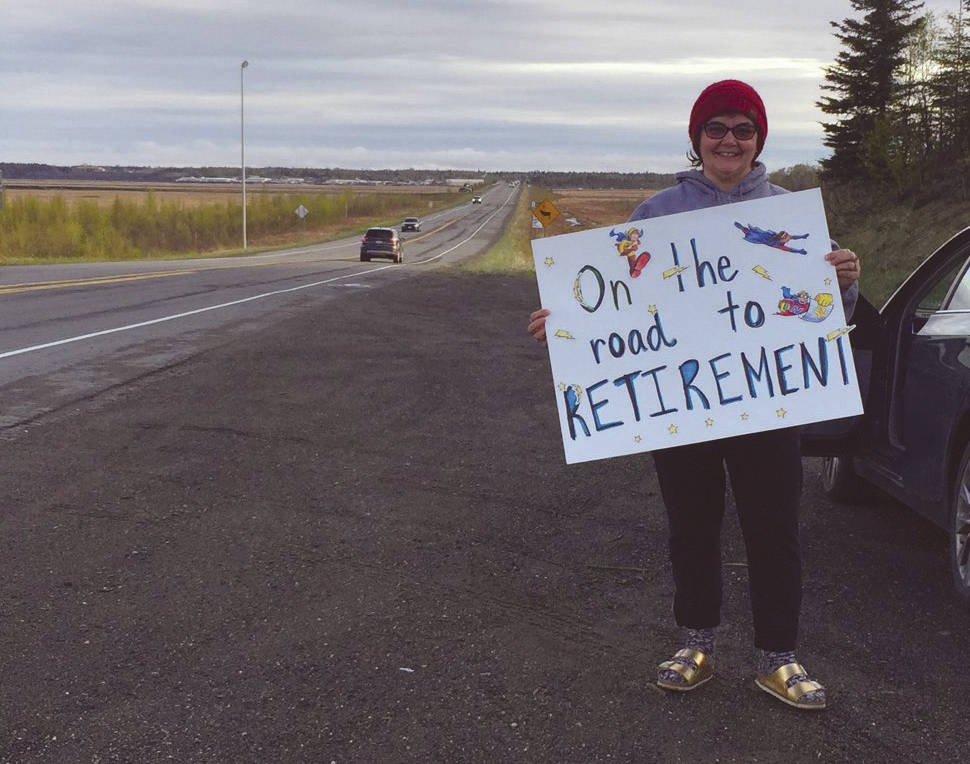 Donna Anderson holds a sign on one of David Daniels final drives to work Tuesday, May 19, 2020, at the intersectin of Bridge Access Road and Kalifornsky Beach Road. Daniel retired after teaching in the Kenai Peninsula Borough School District for 34 years. (Photo provided by Karl Kircher)