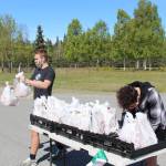 Kenai Peninsula Boys & Girls Clubs employees Michael Eiter, left, and Michael Mysing, right, hand out meals at Kenai Central High School in Kenai, Alaska on May 28, 2020. (Photo by Brian Mazurek/Peninsula Clarion)