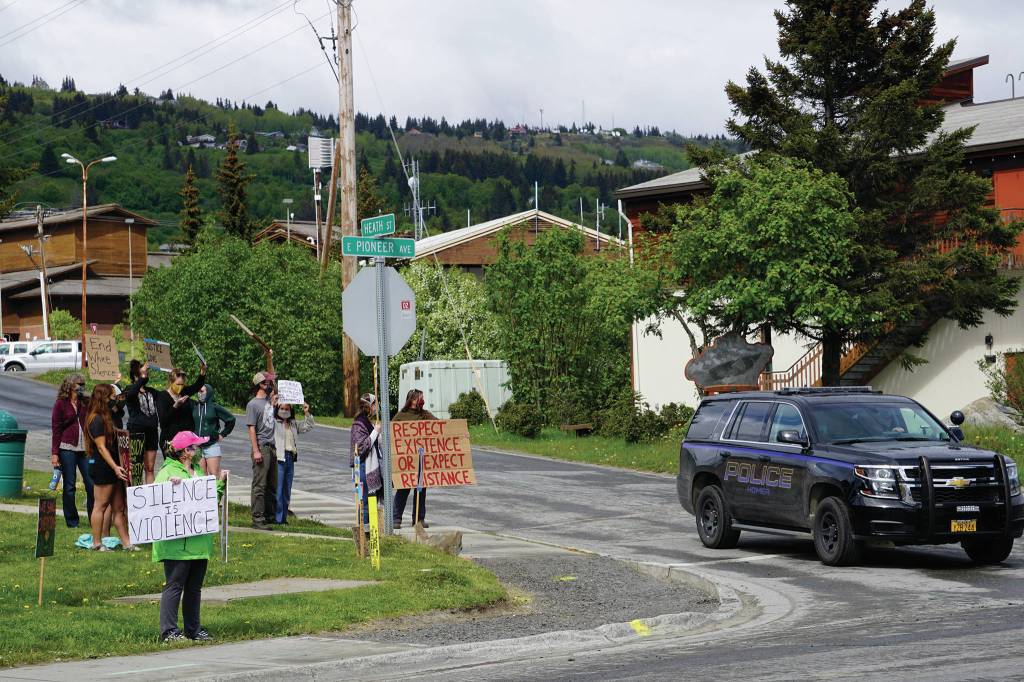 A Homer Police Department officer drives by a protest on Sunday, May 30, 2020, at WKFL Park in Homer, Alaska, in support of people of color who have been the subject of police violence, including George Floyd, a man who died May 25, 2020, in a police encounter in Minneapolis, Minnesota. Demonstrators at the Homer event also held signs that read We (heart) our po po  slang for police  and Thank you, HPD. (Photo by Michael Armstrong/Homer News)