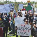 Photo by Jeff Helminiak/Peninsula Clarion                                Black Lives Matter protesters hold up signs at Soldotna Creek Park in Soldotna on Saturday. Front and center is speaker Hannah Warren with her son. She said she debated not bringing her son due to threatening comments the protest drew on Facebook, but wanted him to see everyone who stands with him.