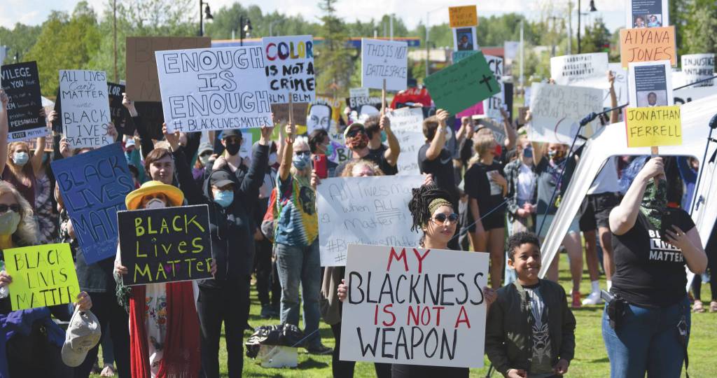 Photo by Jeff Helminiak/Peninsula Clarion                                Black Lives Matter protesters hold up signs at Soldotna Creek Park in Soldotna on Saturday. Front and center is speaker Hannah Warren with her son. She said she debated not bringing her son due to threatening comments the protest drew on Facebook, but wanted him to see everyone who stands with him.